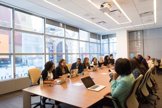 Group of employees sitting around large meeting table