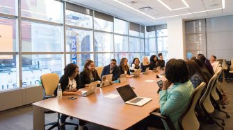Group of employees sitting around large meeting table
