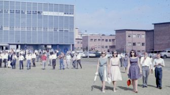 archive image of staff and students walking on campus grounds