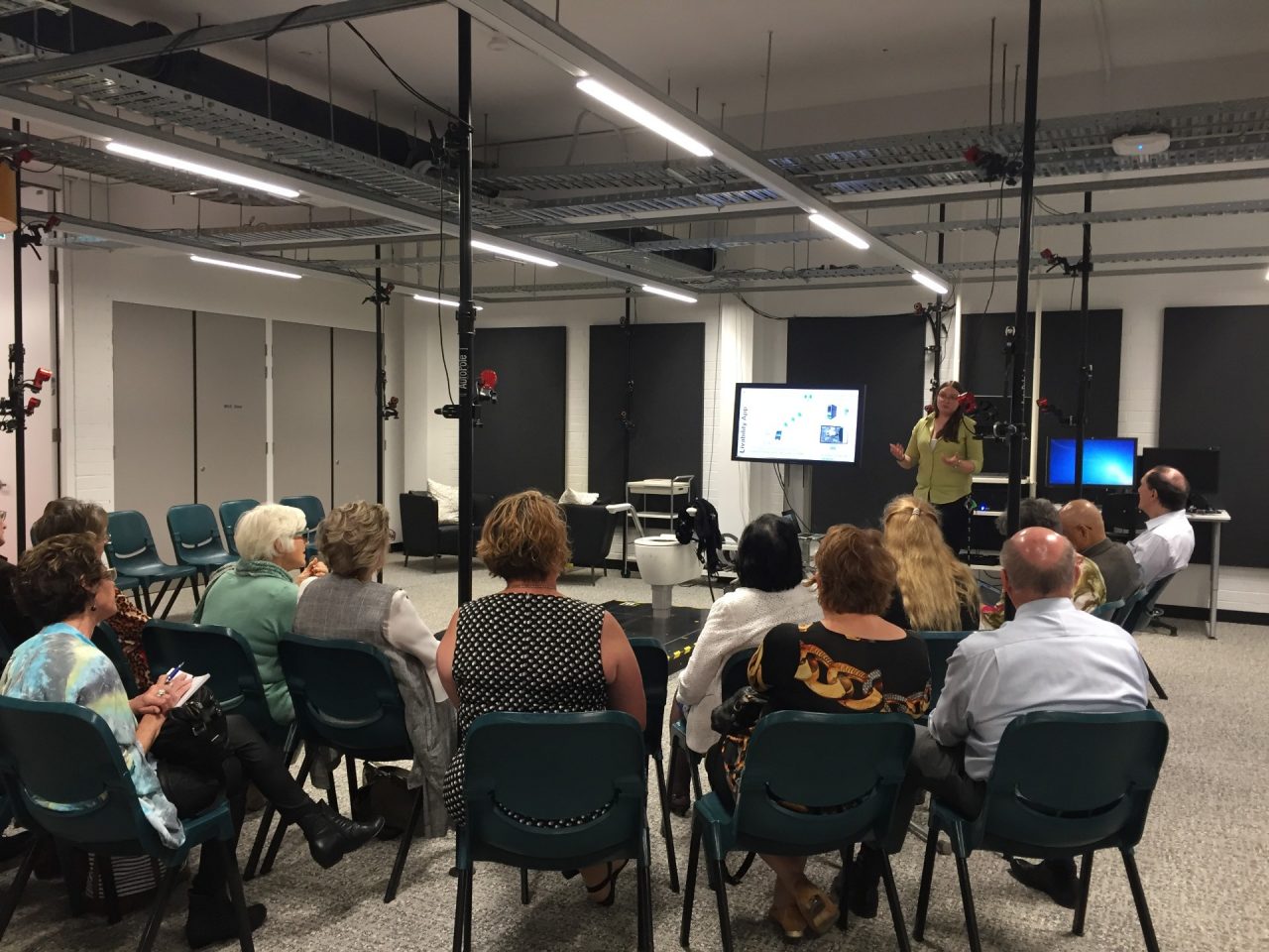 a group of people listenning to a speaker